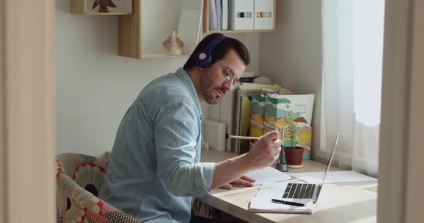 Focused young man studying remotely at home. — Stock Video