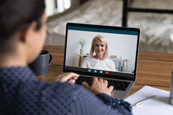 Female employee speak with mature colleague on video call — Stock Photo, Image