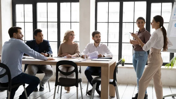 Multiracial female trainers present project on whiteboard in office — Stock Photo, Image