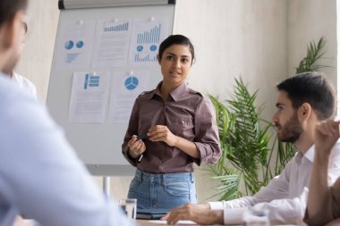 Hintli kadın konuşmacı beyaz tahtada iş projesini sunar