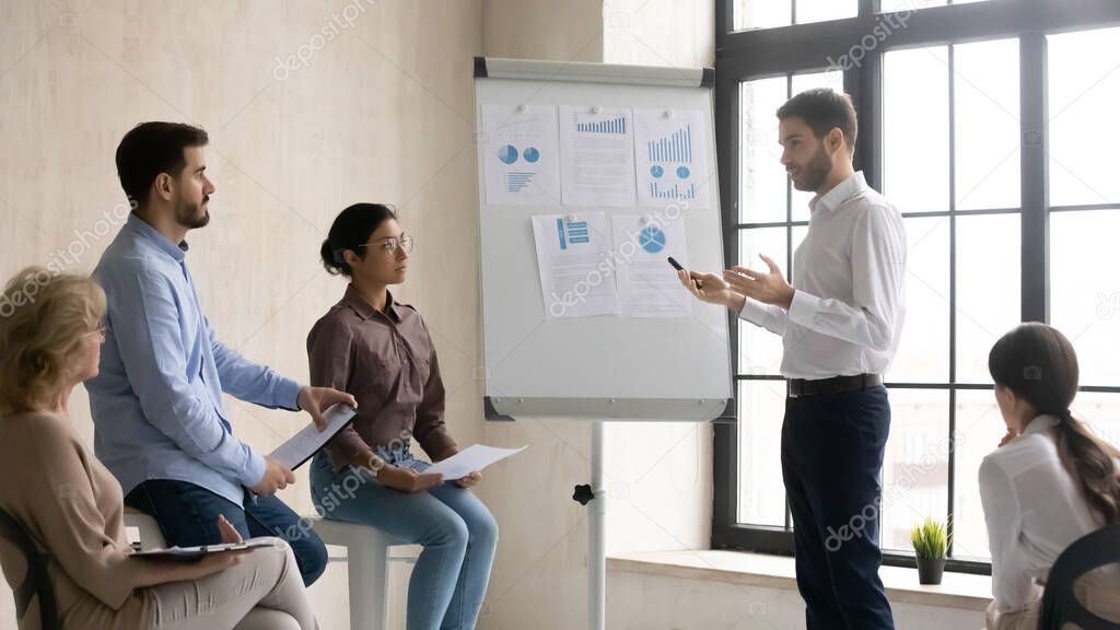 Caucasian male speaker present project on flip chart