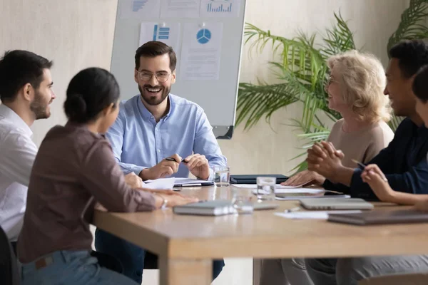 Glimlachende diverse collega 's lachen brainstormen op kantoor — Stockfoto