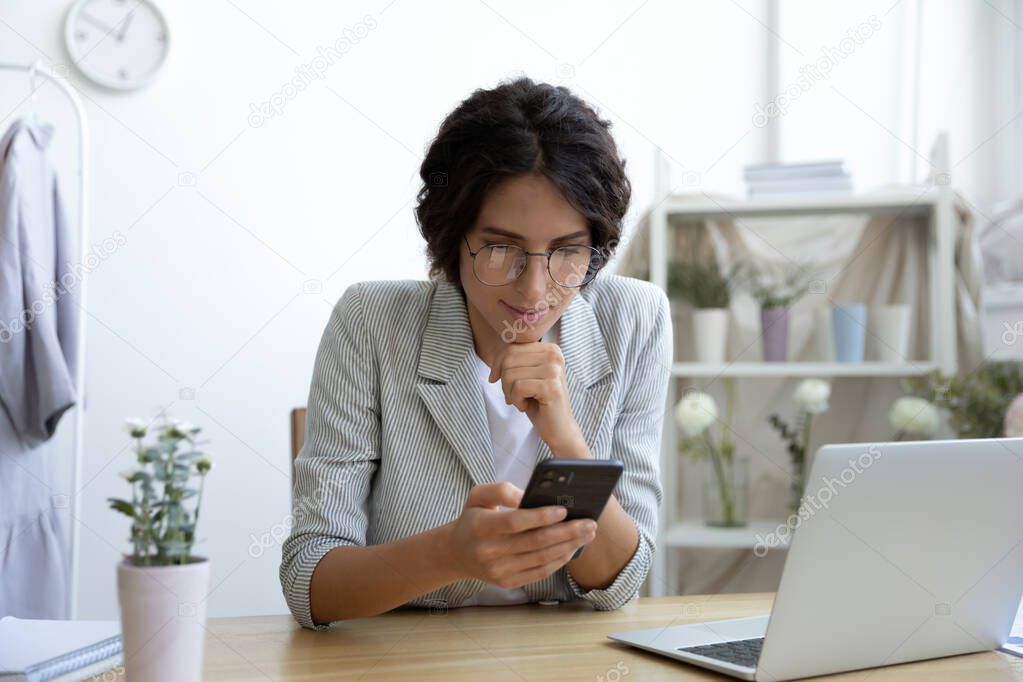 Young Caucasian woman use cellphone at home office