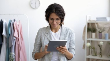 Tabletteki mutlu kadın tasarımcı internette geziniyor