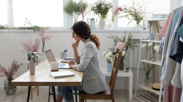 Beyaz kadın çiçekçi ev ofisinde dizüstü bilgisayarda çalışıyor. — Stok fotoğraf
