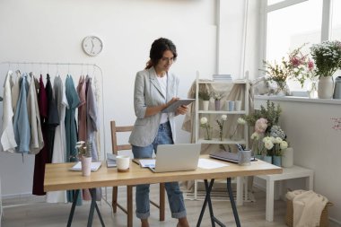 Gülümseyen kadın tasarımcı ev aletleriyle çalışıyor.