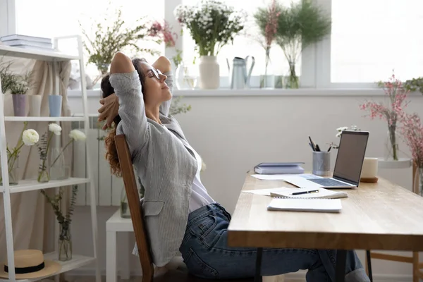 Klidná žena dekoratér relaxovat na židli na pracovišti — Stock fotografie