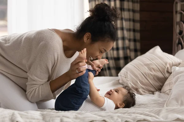 Amorosa biracial madre relajarse en cama jugar con poco bebé —  Fotos de Stock