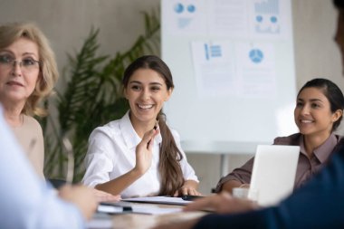 Ofis brifinginde gülümseyen çok ırklı kadın meslektaşlar beyin fırtınası yapıyor.