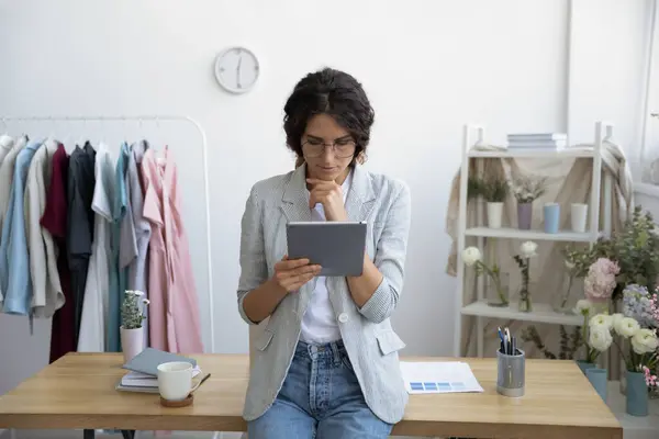 Junge Modedesignerin nutzt Tablet im Büro — Stockfoto