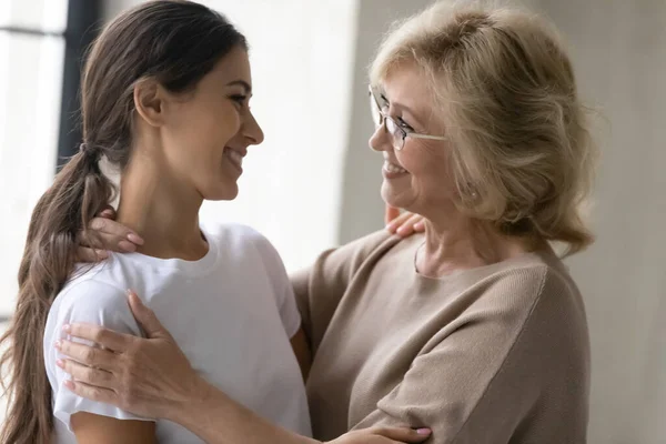 Sonriente de mediana edad mamá y la hija adulta hacer las paces después de la pelea — Foto de Stock