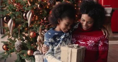 Afrikalı kız Noel hediyesini annesiyle kutluyor.