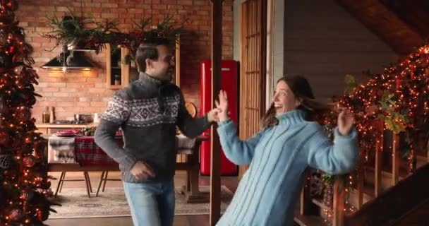 Gelukkig paar dansen in versierd huis vieren kerstavond — Stockvideo