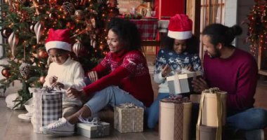 Afrikalı ailelerin çocuklara Noel hediyelerini açmalarına yardım etmesi