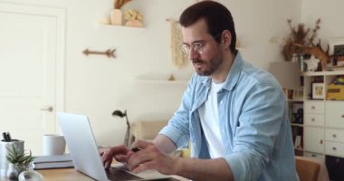 Gözlüklü genç girişimci bilgisayarda çalışıyor..