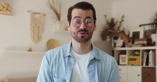 Sonriente joven guapo hombre en gafas celebración de vídeo llamada conversación. — Vídeos de Stock