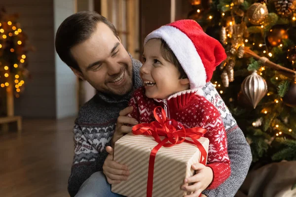 Liebender Papa gratuliert aufgeregtem Sohn mit Weihnachtsgeschenk — Stockfoto