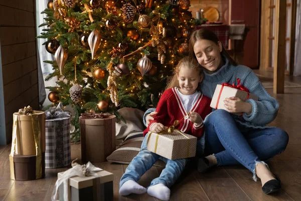 Feliz mamá y su hijita desempaquetan regalos de Navidad — Foto de Stock