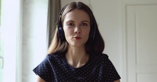 Kablosuz kulaklıklı mutlu Avrupalı kadın video görüşmesi yapıyor.. — Stok video