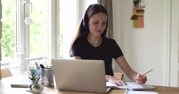Sonriente joven hermosa mujer estudiando remotamente. — Vídeos de Stock