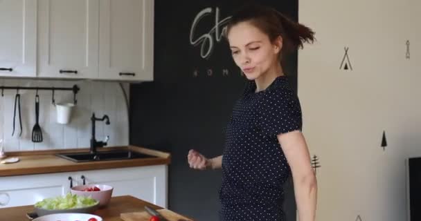 Attraktive junge Europäerin hat Spaß beim Kochen in der Küche. — Stockvideo