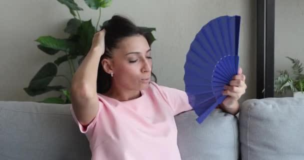 Overheated young indian arabic woman using paper fan. — Stock Video