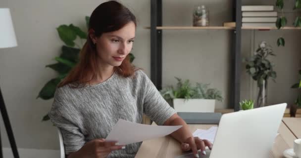 Smiling 30s red-haired businesswoman doing paperwork. — Stock Video