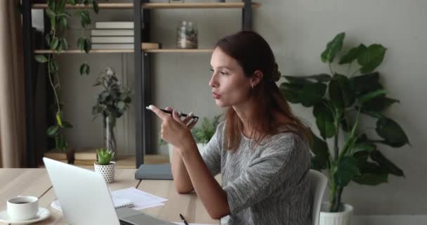 Fokuserad ung 30-talskvinna dikterar ljudmeddelande i mobil applikation. — Stockvideo