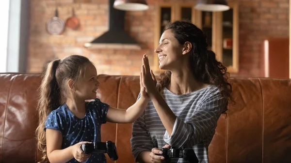 Gelukkig mam en kleine dochter vieren overwinning in video spel — Stockfoto