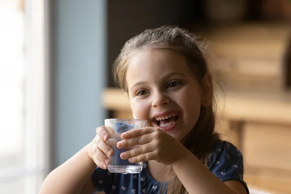 Feliz niña pequeña beber agua mineral todavía —  Fotos de Stock