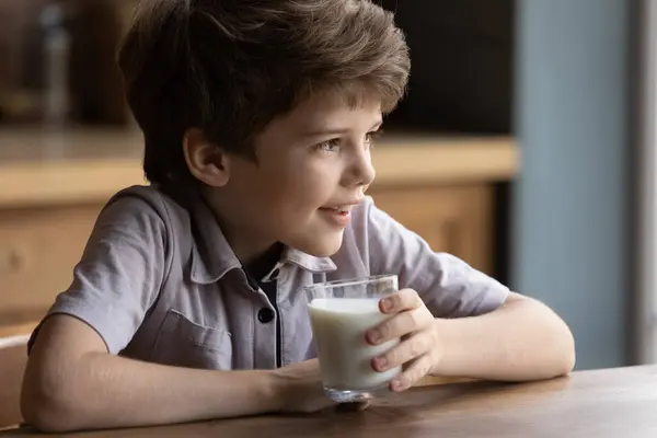 小男孩用杯子喝美味的有机牛奶 — 图库照片