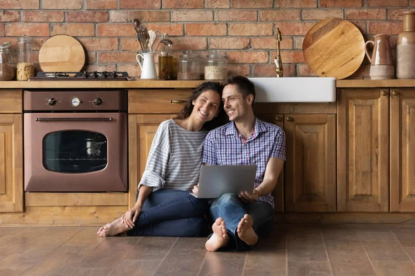 Smiling couple renters relax dreaming of happy future together