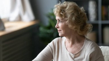 Düşünceli orta yaşlı olgun bir kadın başka tarafa bakıyor..