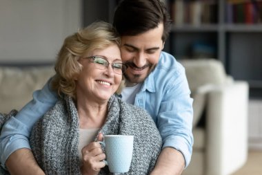 Ekoseye sarılmış, gülümseyen 60 'lı yaşlarda bir anne..