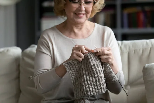 Happy older senior 60s woman knitting warm clothing. — Stock Photo, Image