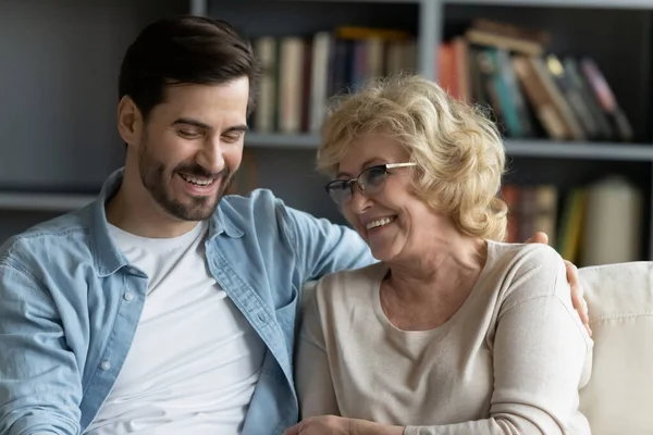 Glad ung man njuter av roliga samtal eller skvallrar med mamma. — Stockfoto