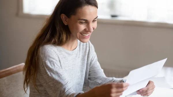 Smiling millennial woman is glad reading letter from beloved person — Stock Photo, Image