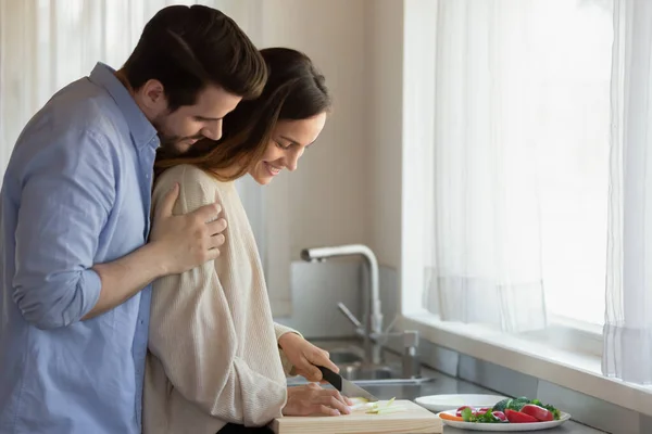 Caring marito millenario abbracciare le spalle della moglie amata preparare la colazione — Foto Stock