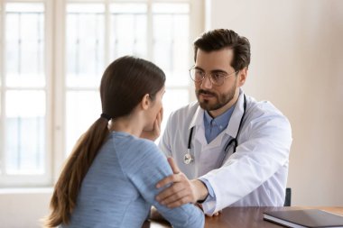 Stresli hastanın omzuna dokunan bakıcı doktor destek gösteriyor.