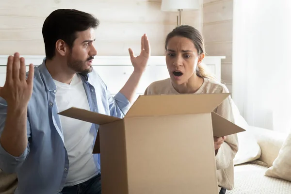 Confus choqué époux millénaires ouvrant la livraison avec des marchandises défectueuses gâtées — Photo