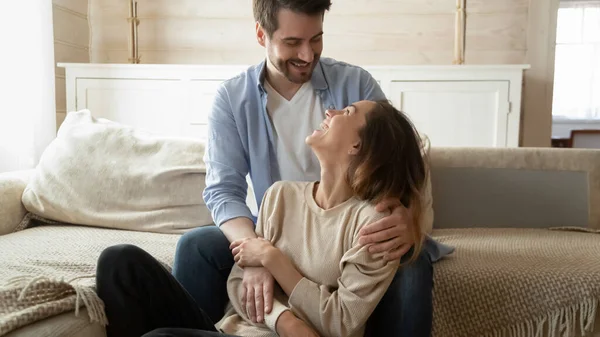 Felices esposos cariñosos acurrucados sonriendo mirando a los ojos dentro —  Fotos de Stock