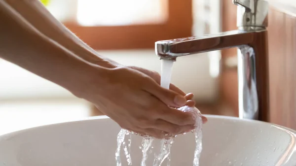 Close up of female washing hands in sink at bathroom — Stock Photo, Image