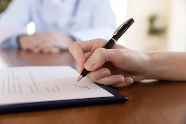 Young female hand holding pen able to sign paper contract — Stock Photo, Image