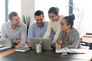 Çevrimiçi projeyi tartışan farklı ırklardan mutlu genç meslektaşlar.