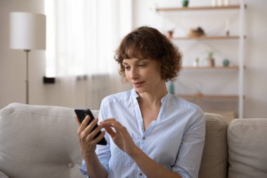 Evdeki telefon ekranına bakan ciddi bir kadını kapat.