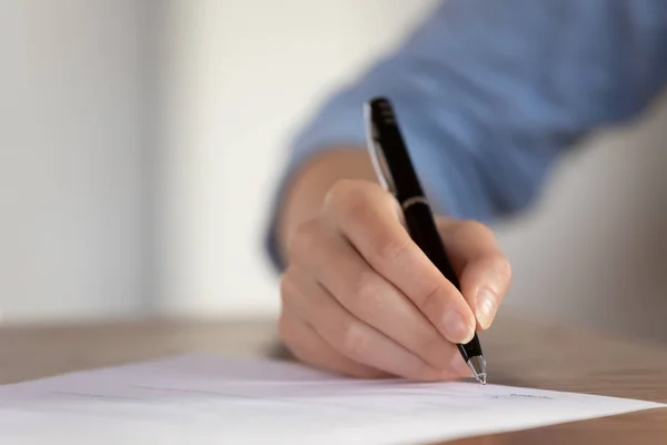 Ung kvindelig hånd med pen klar til at underskrive papirdokument - Stock-foto