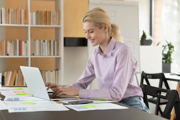 Feliz joven empleada motivada trabajando en la computadora. — Foto de Stock