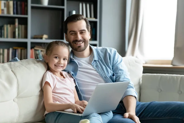 Щасливий молодий тато викладає маленьку доньку за допомогою комп'ютерних додатків . — стокове фото