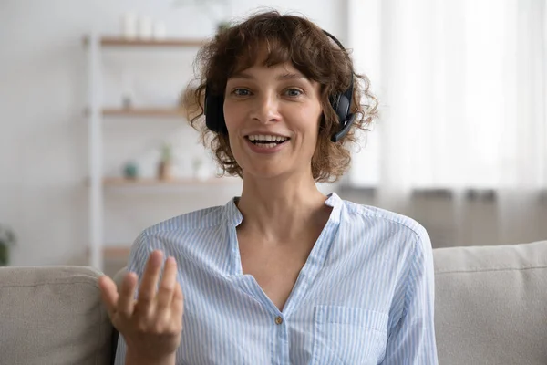 Head shot portrait smiling woman wearing headset speaking to camera