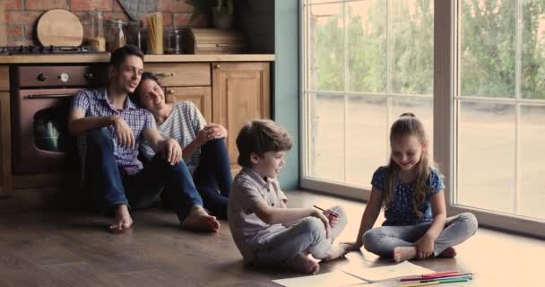 Familjen tillbringar helgen hemma sitter på golvet i köket — Stockvideo